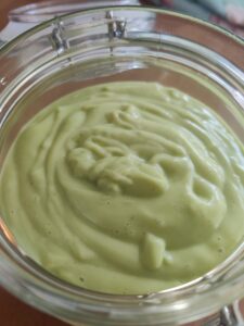 Pale green mayonnaise in a glass jar
