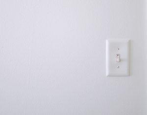 A white light switch on a white wall. Photo by Isabella Fischer on Unsplash.